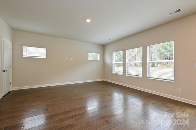 unfurnished room featuring a healthy amount of sunlight and dark hardwood / wood-style floors