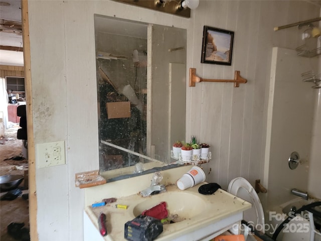 full bath featuring  shower combination, wood walls, and vanity