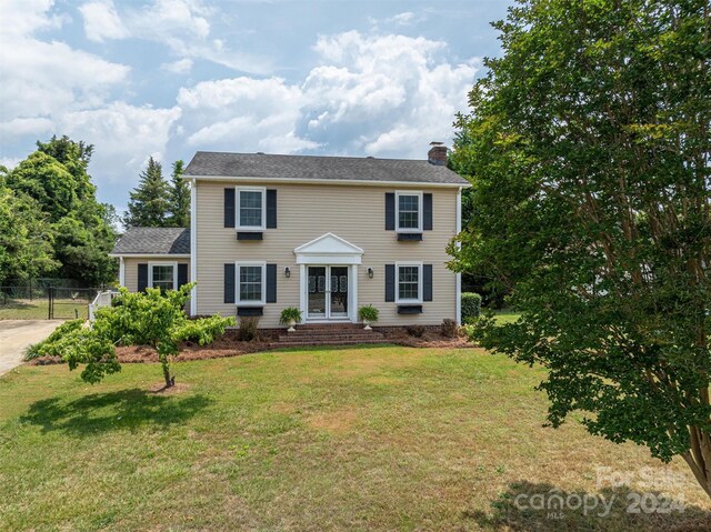 colonial-style house with a front lawn