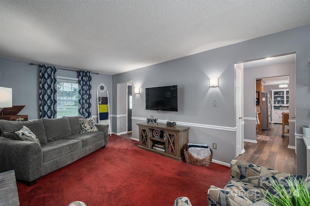 carpeted living room featuring a textured ceiling