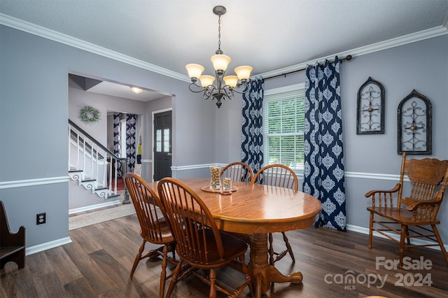 dining space with a textured ceiling, an inviting chandelier, ornamental molding, and dark hardwood / wood-style floors