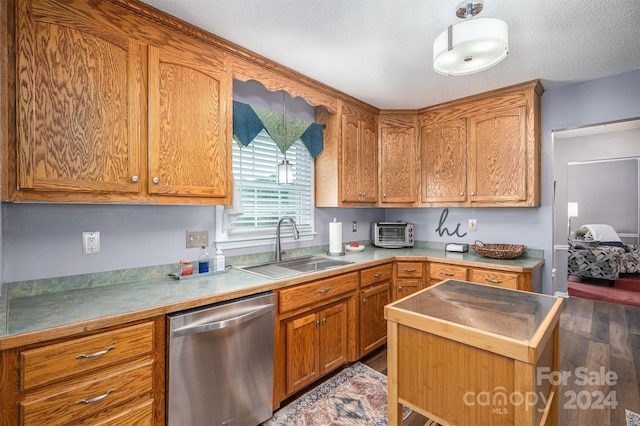 kitchen with sink, wood-type flooring, stainless steel dishwasher, and a textured ceiling