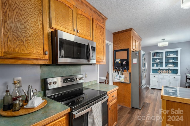 kitchen featuring a textured ceiling, dark wood-type flooring, and appliances with stainless steel finishes