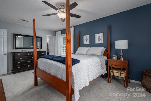 bedroom featuring a textured ceiling, ceiling fan, and carpet