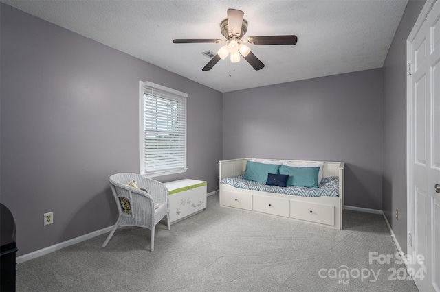 bedroom featuring ceiling fan, carpet floors, and a textured ceiling