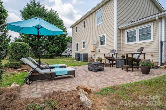 view of patio with central AC unit and a fire pit