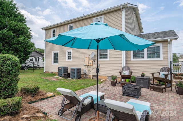 back of house featuring a lawn, central AC unit, and a patio