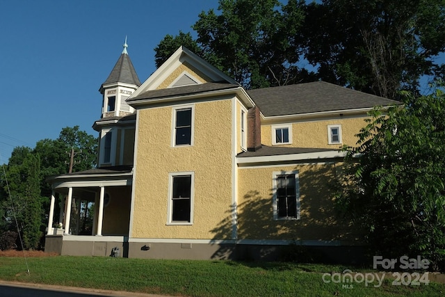 view of home's exterior with a sunroom and a lawn