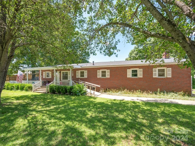 single story home featuring covered porch and a front yard