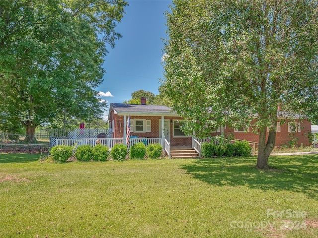 view of front of property with covered porch and a front yard