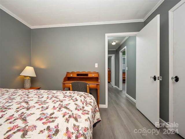 bedroom with light wood-type flooring and crown molding