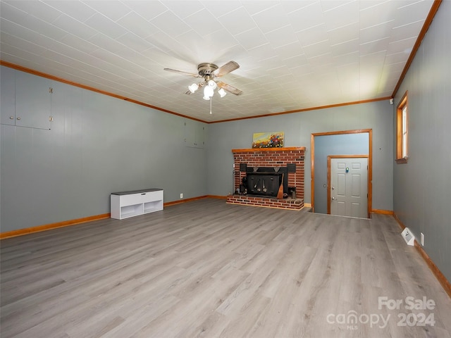 unfurnished living room featuring a fireplace, light hardwood / wood-style floors, ceiling fan, and crown molding