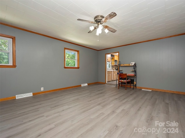 spare room featuring plenty of natural light, ceiling fan, ornamental molding, and light hardwood / wood-style flooring