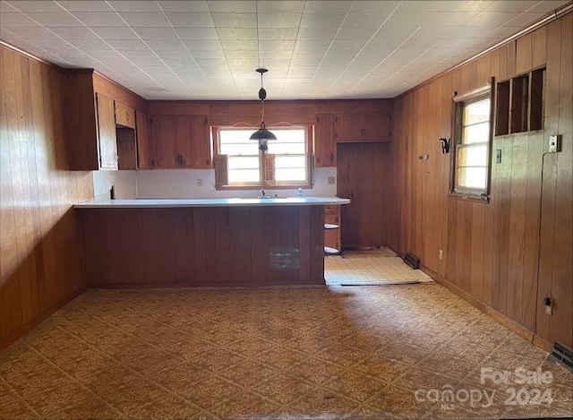 kitchen featuring kitchen peninsula and wooden walls