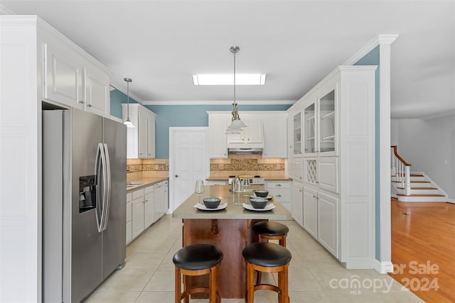 kitchen featuring pendant lighting, white cabinets, and stainless steel appliances