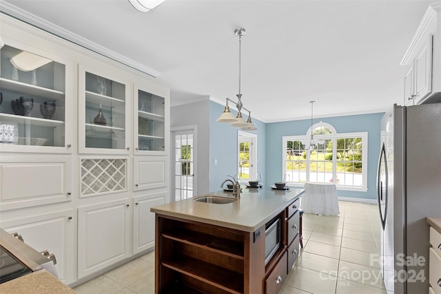 kitchen with white cabinetry, sink, an island with sink, light tile patterned floors, and appliances with stainless steel finishes