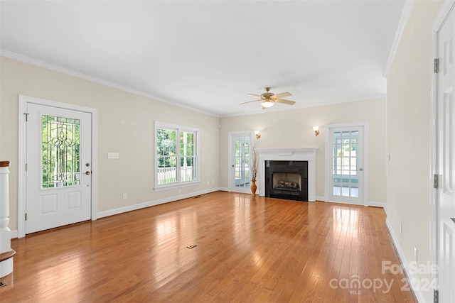 unfurnished living room with a wealth of natural light, ceiling fan, and crown molding