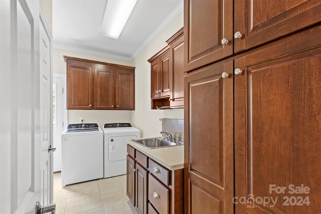 laundry room with cabinets, ornamental molding, washer and clothes dryer, sink, and light tile patterned floors