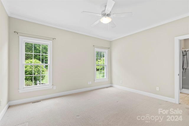 carpeted empty room featuring ceiling fan and crown molding