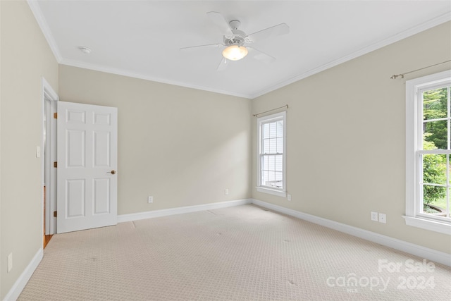 spare room featuring ceiling fan, crown molding, and light carpet