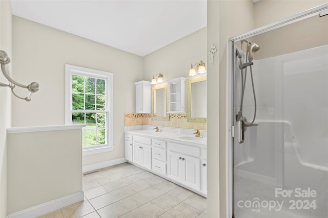 bathroom with backsplash, tile patterned flooring, vanity, and an enclosed shower