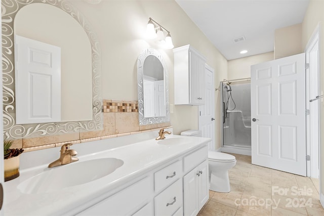 bathroom featuring tile patterned floors, a shower with door, vanity, and toilet