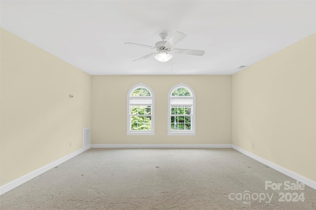 carpeted spare room featuring ceiling fan