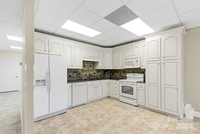 kitchen with white cabinets, white appliances, a drop ceiling, and sink