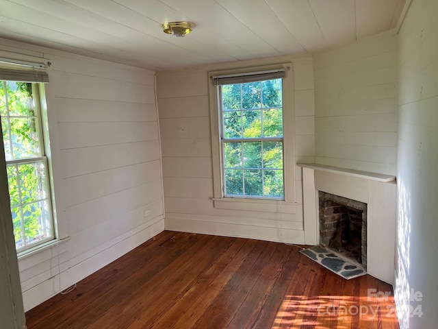 unfurnished living room with wood walls and dark wood-type flooring