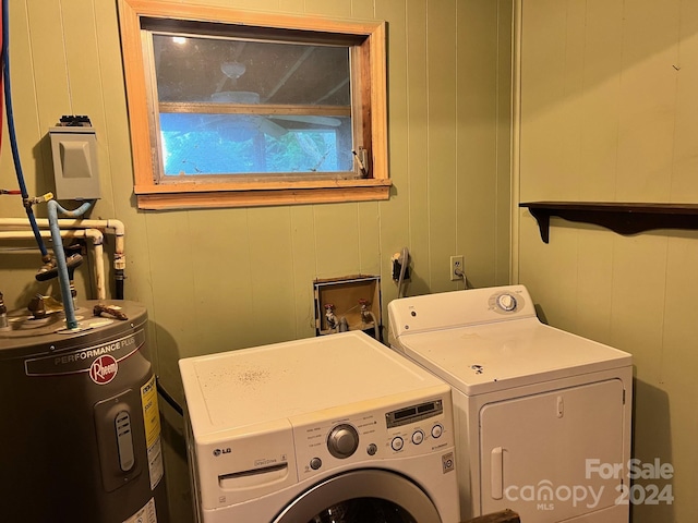 washroom with electric water heater, wooden walls, and washer and dryer