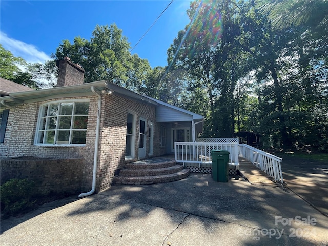 view of side of property with a patio and a deck