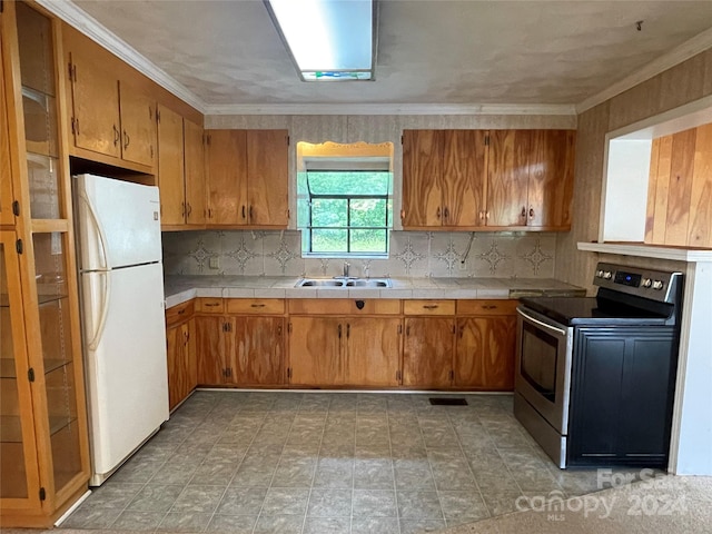 kitchen featuring tasteful backsplash, sink, white refrigerator, ornamental molding, and stainless steel electric range