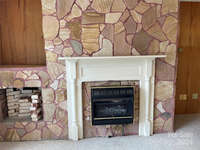 room details with a stone fireplace, carpet floors, and heating unit