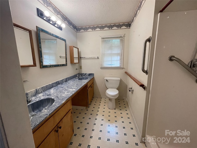 bathroom featuring vanity, a textured ceiling, and toilet