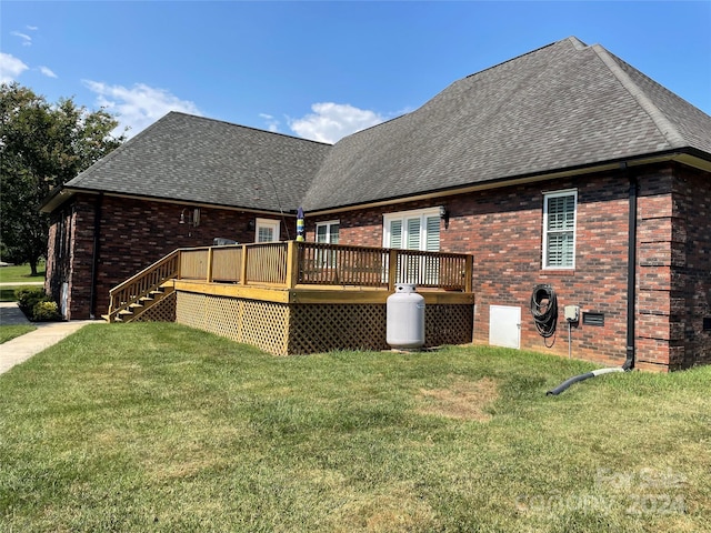 back of house featuring a deck and a lawn