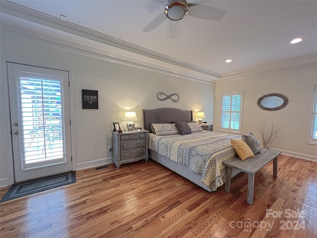 bedroom featuring light wood finished floors, baseboards, visible vents, and ornamental molding