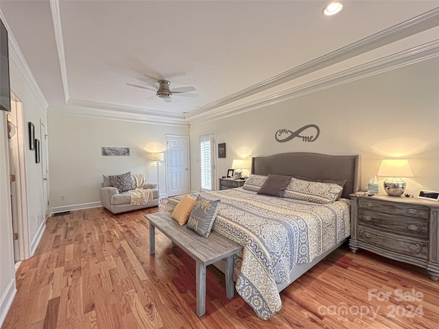 bedroom with light wood-style floors, baseboards, and crown molding