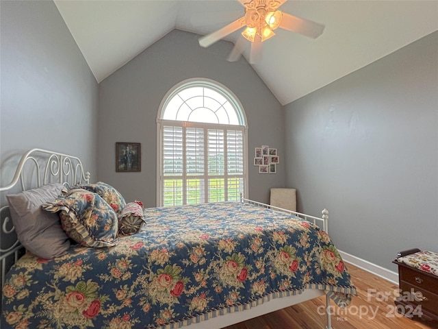 bedroom with ceiling fan, hardwood / wood-style floors, and vaulted ceiling