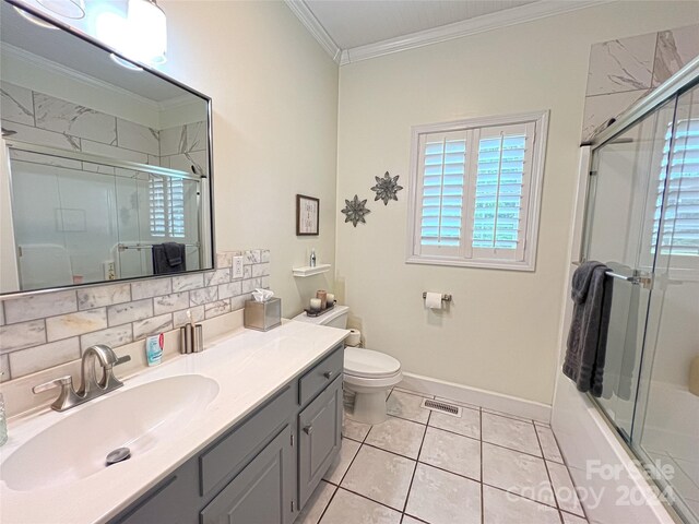 full bathroom featuring tile patterned floors, vanity, backsplash, toilet, and ornamental molding