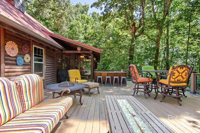 deck with an outdoor living space and exterior bar