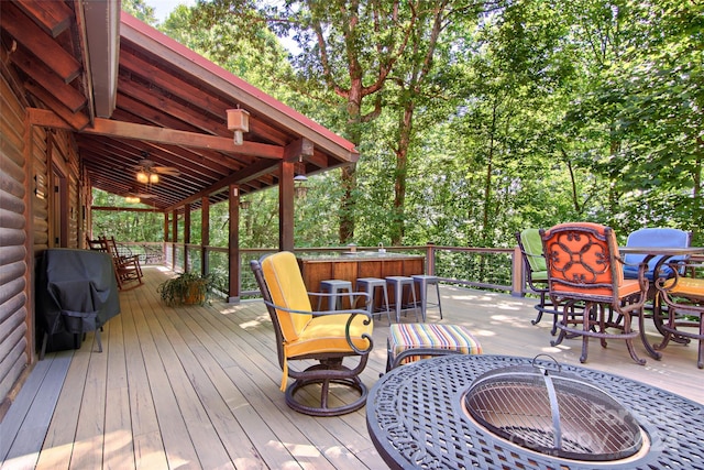 wooden terrace with exterior bar and an outdoor fire pit