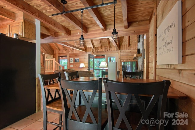 interior space featuring light tile patterned flooring, vaulted ceiling with beams, wood ceiling, and wood walls