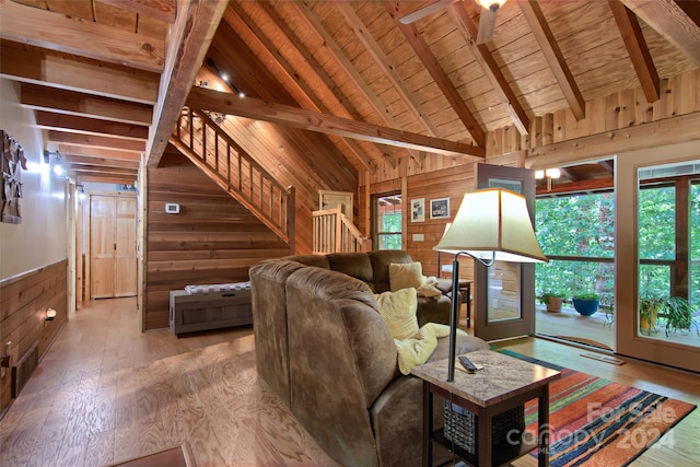 living room with wood ceiling, wood walls, hardwood / wood-style floors, and lofted ceiling with beams