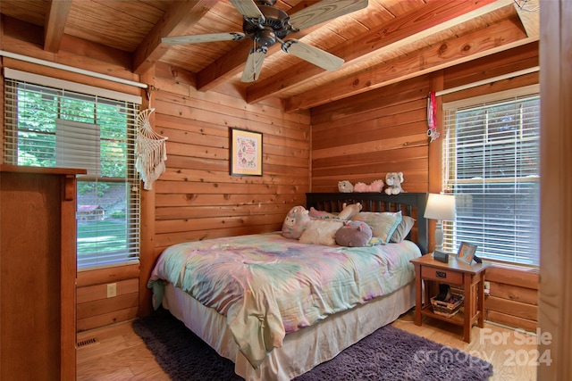 bedroom with wooden ceiling, wooden walls, light hardwood / wood-style flooring, ceiling fan, and beamed ceiling