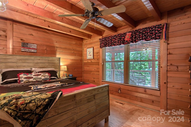 bedroom featuring wood walls, wooden ceiling, light hardwood / wood-style flooring, ceiling fan, and beamed ceiling