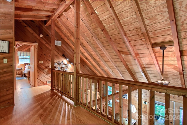 hall featuring hardwood / wood-style flooring, lofted ceiling with beams, wooden ceiling, and wooden walls