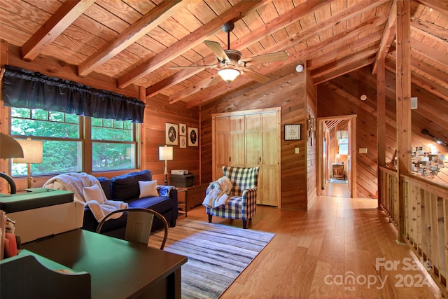 living room featuring light wood-type flooring, lofted ceiling with beams, and wooden walls