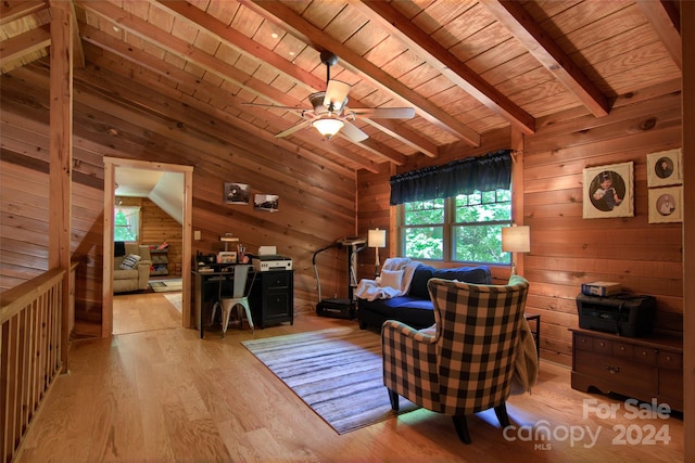 living room featuring ceiling fan, vaulted ceiling with beams, wooden walls, wood ceiling, and light wood-type flooring