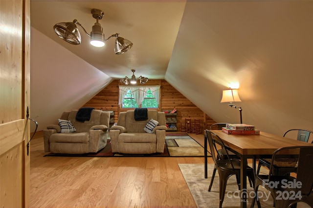 home theater room with vaulted ceiling, light hardwood / wood-style flooring, and wooden walls