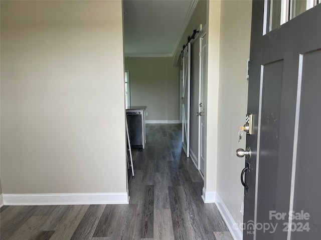 corridor with crown molding, dark hardwood / wood-style flooring, and a barn door